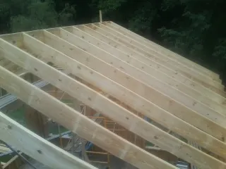 New roof rafters set over an addition before sheathing in Newburg
