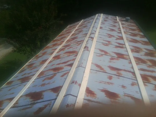 Rusted metal roof panels with new wood purlins before replacement — Storm Damage Roof Repair in Newburg by Roofing Brothers