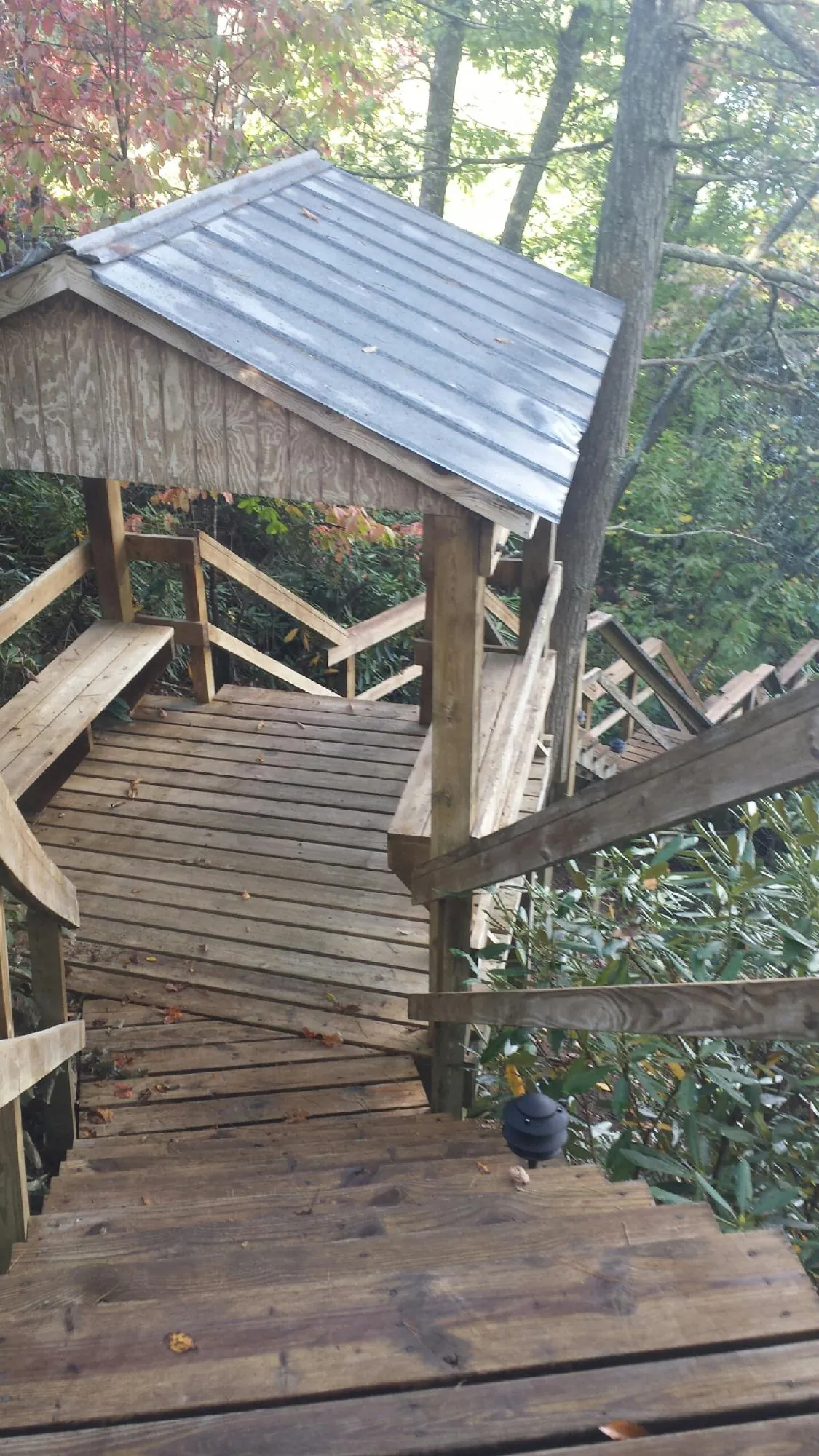 Metal roofed shelter over wooden steps on a wooded walkway — Skylight Repair & Installation work by our crew in Newburg